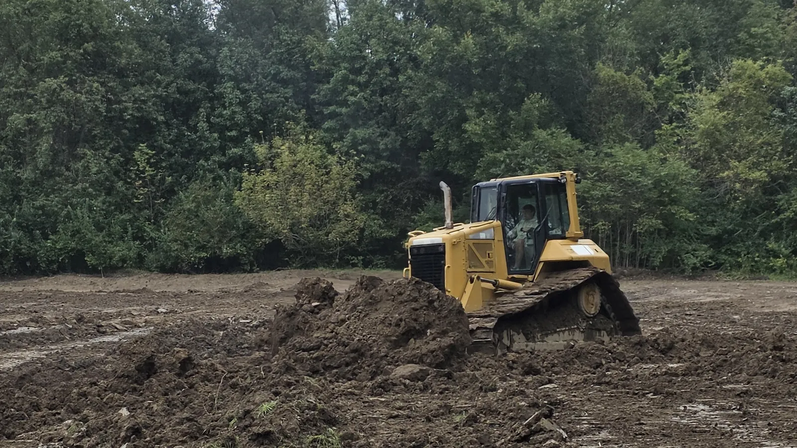 Elite Site Solutions bulldozer pushing dirt on a job site